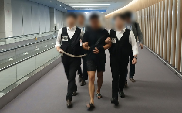 해킹 범죄조직의 총책급 범죄인인 중국 국적 A씨가 22일 태국 방콕에서 인천국제공항으로 송환돼 입국하고 있다 ⓒ법무부