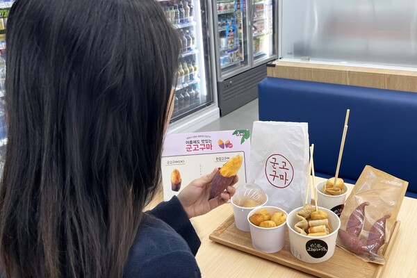 GS25에서 소비자가 한입 군고구마를 비롯해 겨울 간식을 먹고 있는 연출샷 ⓒGS리테일