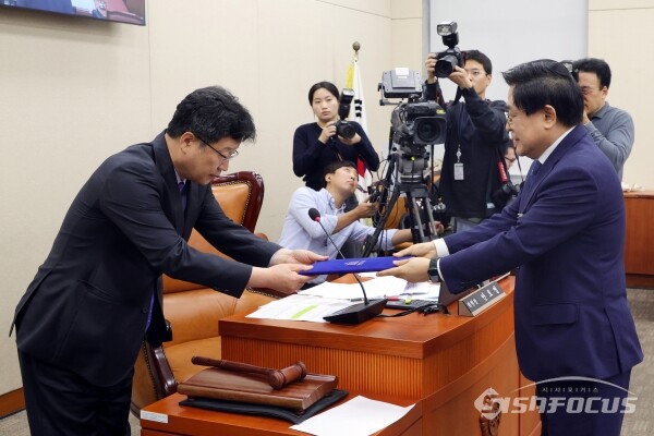 15일 도세호 대표가 증인 선서 후 선서문을 안호영 위원장에게 전달하고 있다.(2) [사진 / 오훈 기자]