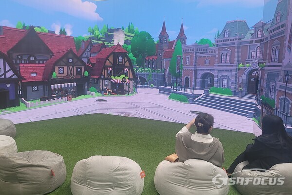 서울 성동구에서 개최 중인 '모험가의 기록전'에서 방문객이 던바튼 광장을 배경을 휴식을 취하고 있다. [사진 / 임솔 기자]