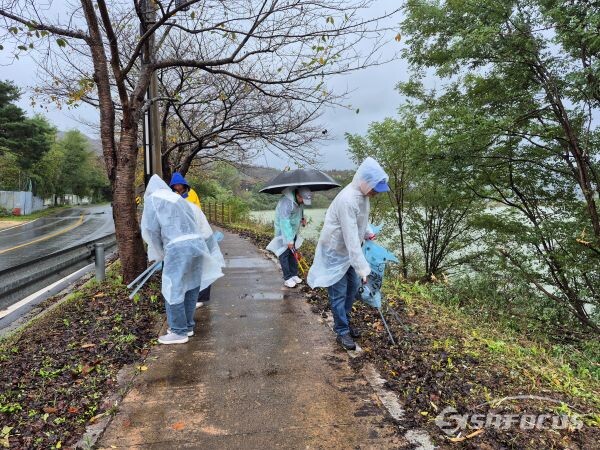 도로변 인도에 버려진 휴지를 치우고 있는 모습. 사진/김인철 기자