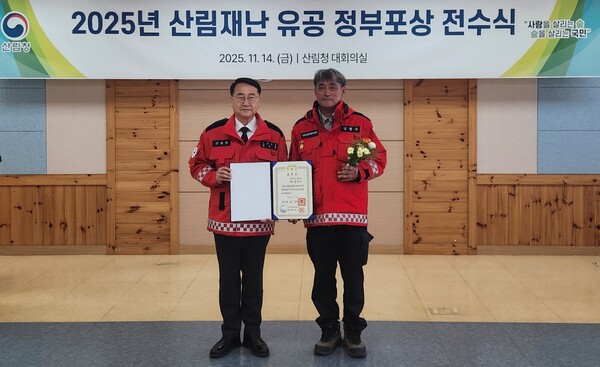 14일 김인호 산림청장(왼쪽)이 ‘2025년 산림재난 유공자 포상식’에서 김영수 영덕군 산불진화대장에게 대통령 표창을 전수하고 기념 촬영을 하고 있다.ⓒ영덕군